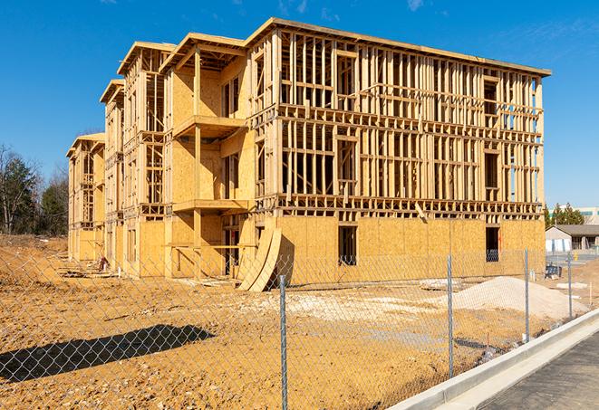 workers protected by temporary barrier fence during building maintenance in Ashland